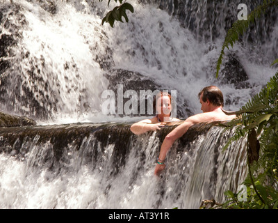 Costa Rica La Fortuna Tabacon Hot Springs Resort gli ospiti seduti in piscina tra riscaldata termicamente cascate Foto Stock