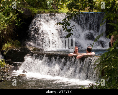 Costa Rica La Fortuna Tabacon Hot Springs Resort gli ospiti seduti in piscina tra riscaldata termicamente cascate Foto Stock