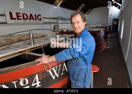 Whisky Tobermory Distillery, Isle of Mull. Mash uomo Colin corazza effettuare controlli per gravità sul washback. Ebridi Interne, Scozia Foto Stock