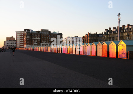 Cabine sulla spiaggia, sul lungomare Hove durante il tramonto, Brighton e Hove, East Sussex, Inghilterra Foto Stock