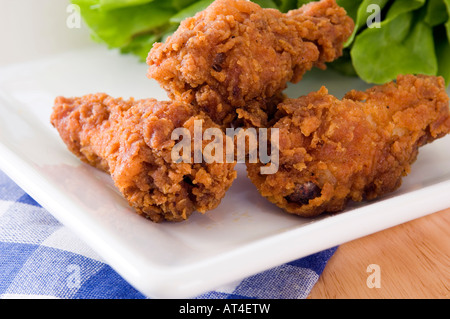 Una piastra con golden deep fried chicken wings visualizzati con una gamma di confezioni di salse Foto Stock