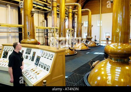 Glenmorangie Distillery a Tain. Ancora uomo Robert Nicholson sovrintende la pentola di rame alambicchi in camera ancora. Highland, Scozia Foto Stock