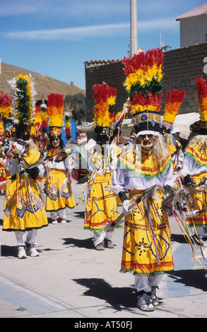 Danzatori guerrieri Tobas che indossano copricapi in piuma nei colori nazionali boliviani, CH'utillos festival, Potosi, Bolivia Foto Stock