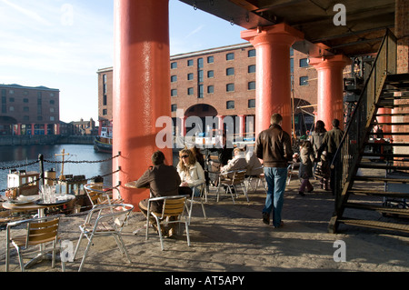 La gente seduta a mangiare bere outdoor cafe bar nel ristrutturato e rinnovato Albert Dock Liverpool England Regno Unito Foto Stock