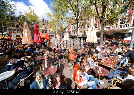 Inizio della primavera in Amsterdam. Tutte le terrazze dei bar della piazza Leidseplein sono imballate. Celebrazione del compleanno del re. Foto Stock