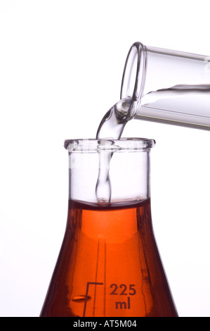 Vista ingrandita del liquido che viene versato dal tubo di prova nella beuta di Erlenmeyer in laboratorio Foto Stock