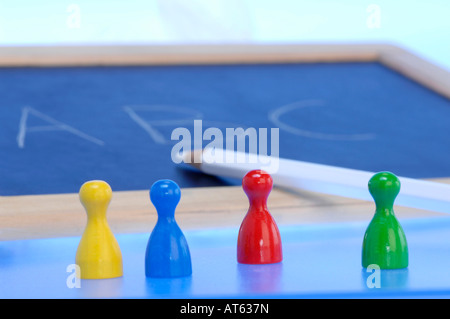 Lavagna con matita e pezzi di gioco, close-up Foto Stock