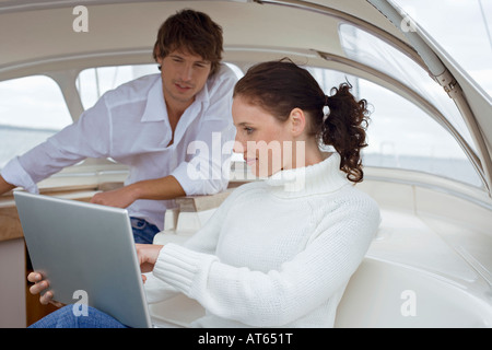 Germania, Mar Baltico, Lübecker Bucht, giovane donna utilizzando laptop in barca a vela, close-up Foto Stock