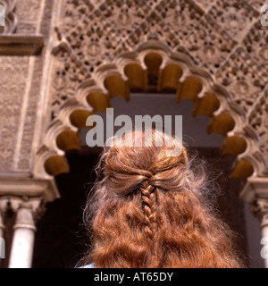 Una donna turista con treccia di treccia di capelli rossi intrecciata che guarda i dettagli dell'architettura al Real Alcazar a Siviglia Spagna Europa UE KATHY DEWITT Foto Stock