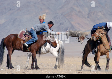 Il kazako due piloti in lotta per il controllo di una capra morto in un gioco di Kokpar o Bushkashi a l'Aquila annuale Festival di caccia Foto Stock