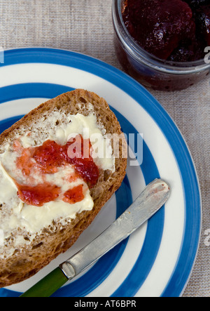 Pane integrale spalmato di burro organico e confettura di fragole Foto Stock