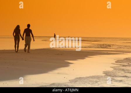 Coppia sulla spiaggia, stagliano al tramonto, Maldive Foto Stock