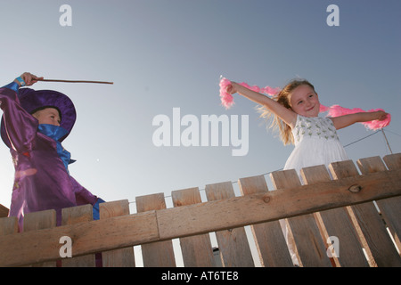 Procedura guidata ragazzo con la bacchetta magica e la ragazza bionda tenendo giù boa Foto Stock
