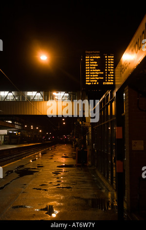 Stazione ferroviaria scheda di partenza sulla piattaforma della stazione a tarda notte Foto Stock