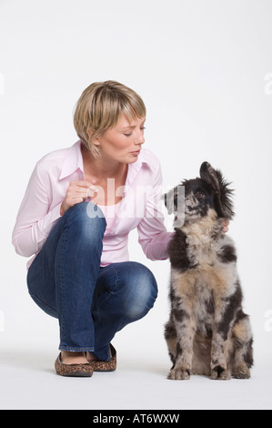 Giovane donna accovacciata dal cane, ritratto Foto Stock