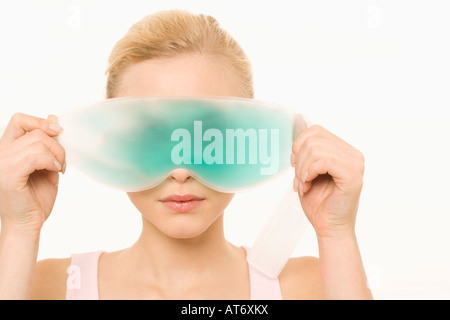 Giovane donna che indossa un Gel Eye Mask, ritratto Foto Stock