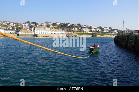 Un Dinghy ormeggiati alla banchina in St Mawes villaggio su un chiaro gli inverni di giorno con Rosevine Hotel dietro Foto Stock