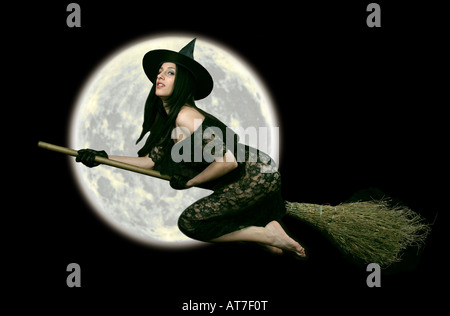 Fantasy strega Halloween su un bastone di scopa volare oltre la Luna Foto Stock