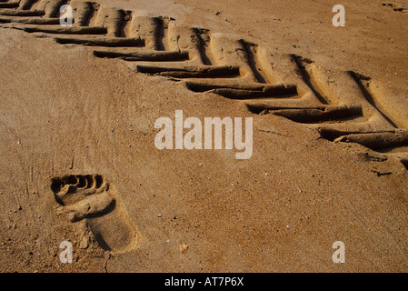 Traccia di ruota e piede stampa sulla spiaggia di sabbia Foto Stock