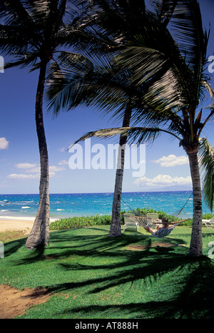 Vacanziere in amaca a Ulua beach, Wailea, Maui. Isola di Lanai offshore Foto Stock