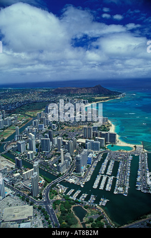 Riprese aeree di Ala Wai Boat Harbour, Waikiki Beach Hotel & il cratere del Diamond Head. Enormi nuvole bianche sopra deriva blu del Pacifico Foto Stock