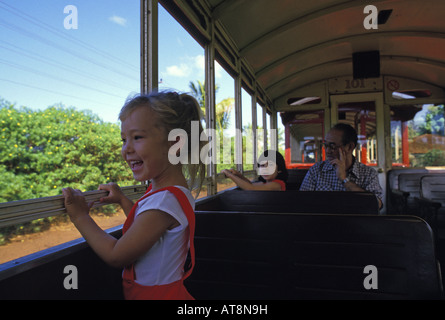 Una giovane ragazza ride con gioia come lei guarda fuori dalla finestra del treno canna da zucchero in Lahaina, Maui. Foto Stock