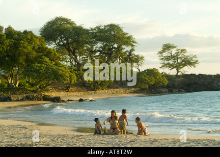 Famiglia gioca sulla riva della baia di Kaunaoa, quali fronti il favoloso Mauna Kea Beach hotel in Kamuela sulla North Kohala Coast. Foto Stock