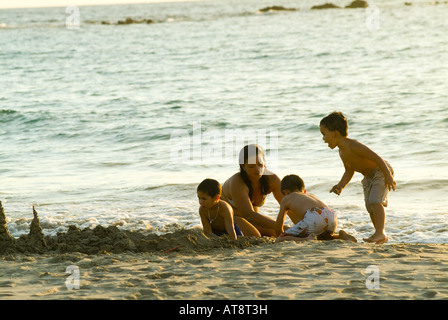 Famiglia gioca sulla riva della baia di Kaunaoa, quali fronti il favoloso Mauna Kea Beach hotel in Kamuela sulla North Kohala Coast. Foto Stock
