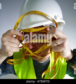 Lavoratore edile con un intricato nastro di misurazione Foto Stock