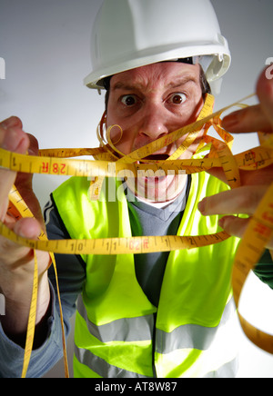 Lavoratore edile con un intricato nastro di misurazione Foto Stock