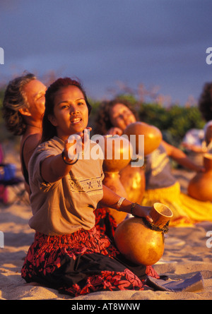 Hula dancers in Makapuu Point di danza noho hula con ipu ( zucca) all'alba sulla spiaggia Foto Stock