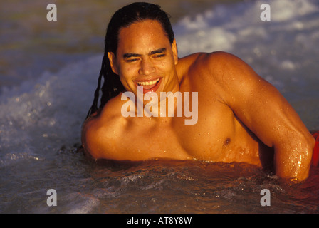 Giovane uomo hawaiana al sorgere del sole sulla spiaggia, Oahu Foto Stock