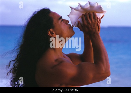Giovane uomo hawaiana al sorgere del sole sulla spiaggia, Oahu Foto Stock
