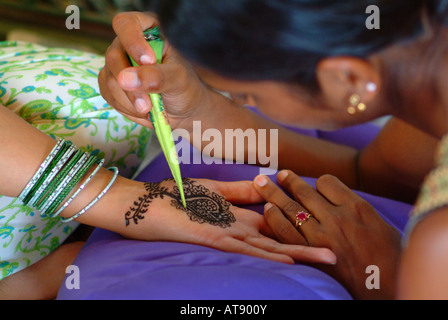 La donna riceve un mendhi henna design all'interno del palmo di una mano in preparazione per la sua hindi cerimonia di nozze Foto Stock