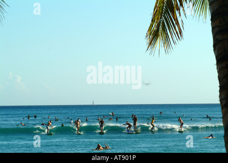 La spiaggia di Waikiki con molti surfisti cavalcare onde piccole nel vicino al litorale Foto Stock