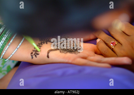 La donna riceve un mendhi ( henna dye ) design sulla sua mano prima della sua indiano cerimonia di nozze Foto Stock