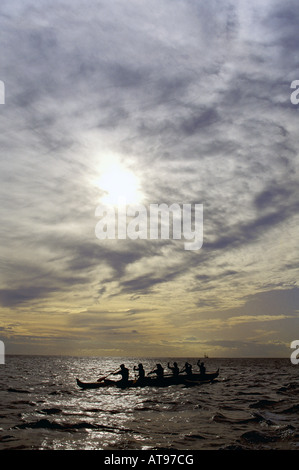 Pagaiando una canoa outrigger Waikiki off nel tardo pomeriggio, con sole quasi l'impostazione. Foto Stock