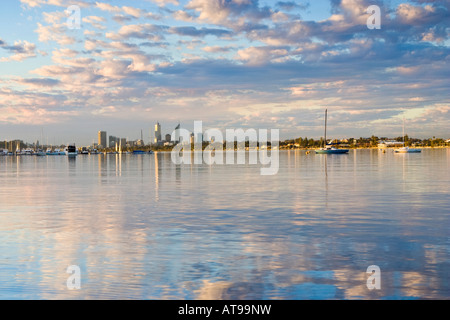 Nuvole riflettono nel fiume Swan al tramonto con grattacieli della città a distanza Foto Stock
