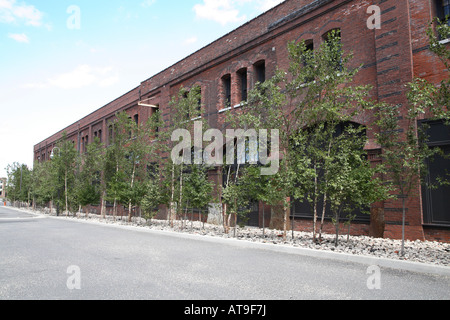 Mattone edificio a due piani con campate di archi romani riempito con molti rettangolare vetrata e finestre ad arco e le porte. Foto Stock