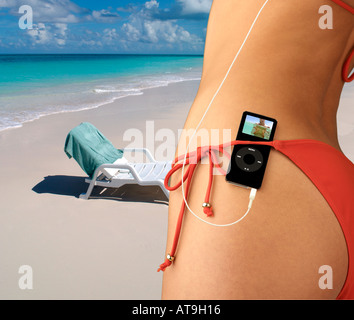 Donna con iPod nano nascosto in rosso cintura bikini in ambiente tropicale Foto Stock