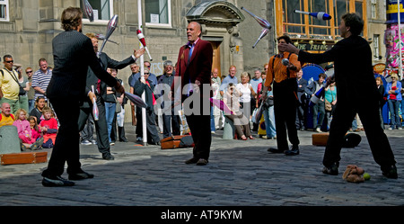 Artisti di strada buttare destreggiarsi tra i club passato a colleghi testa mentre egli si erge nel mezzo Edinburgh Fringe Festival Scozia Foto Stock