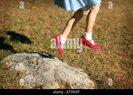 Un bambino vestito come dorothy dal Wizard of Oz, saltando con il suo rosso rubino pantofole Foto Stock