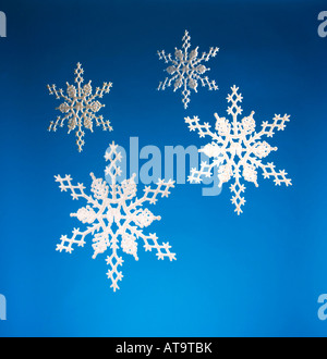 Scheda di Natale - Bianco Natale decorazioni snowflake appeso contro uno sfondo blu Foto Stock