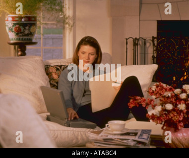 Donna al lavoro su lettino con computer portatile MR Foto Stock