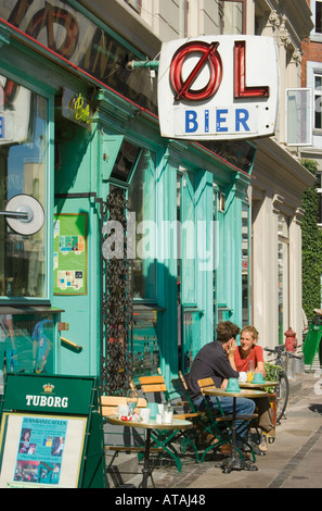 Copenhagen DANIMARCA Coppia giovane assunzione di bevande al tavolo al di fuori del cafè sul marciapiede Foto Stock