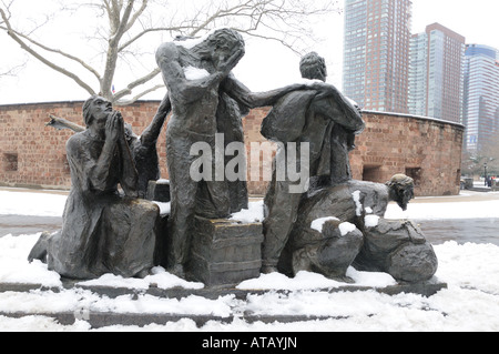 Una statua chiamata gli immigrati si erge al di fuori di Castle Clinton nel Battery Park. Foto Stock