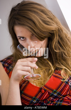 Giovane donna bionda che bere un bicchiere di sherry Foto Stock