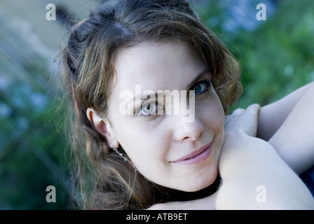 Giovane donna con la testa sul suo bracci incrociati Foto Stock