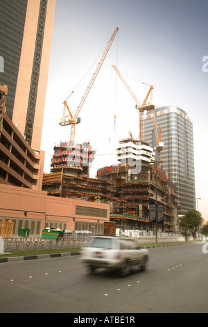 Una velocità di auto passato un grattacielo in costruzione, citta' di Abu Dhabi, Emirati arabi uniti Foto Stock