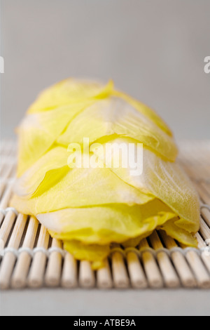 Le cicorie di Bruxelles sul tappetino di bambù Foto Stock